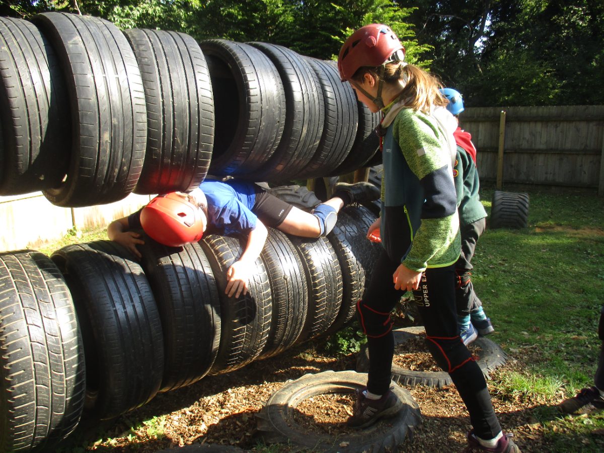 A Cub climbing through a tyre tunnel